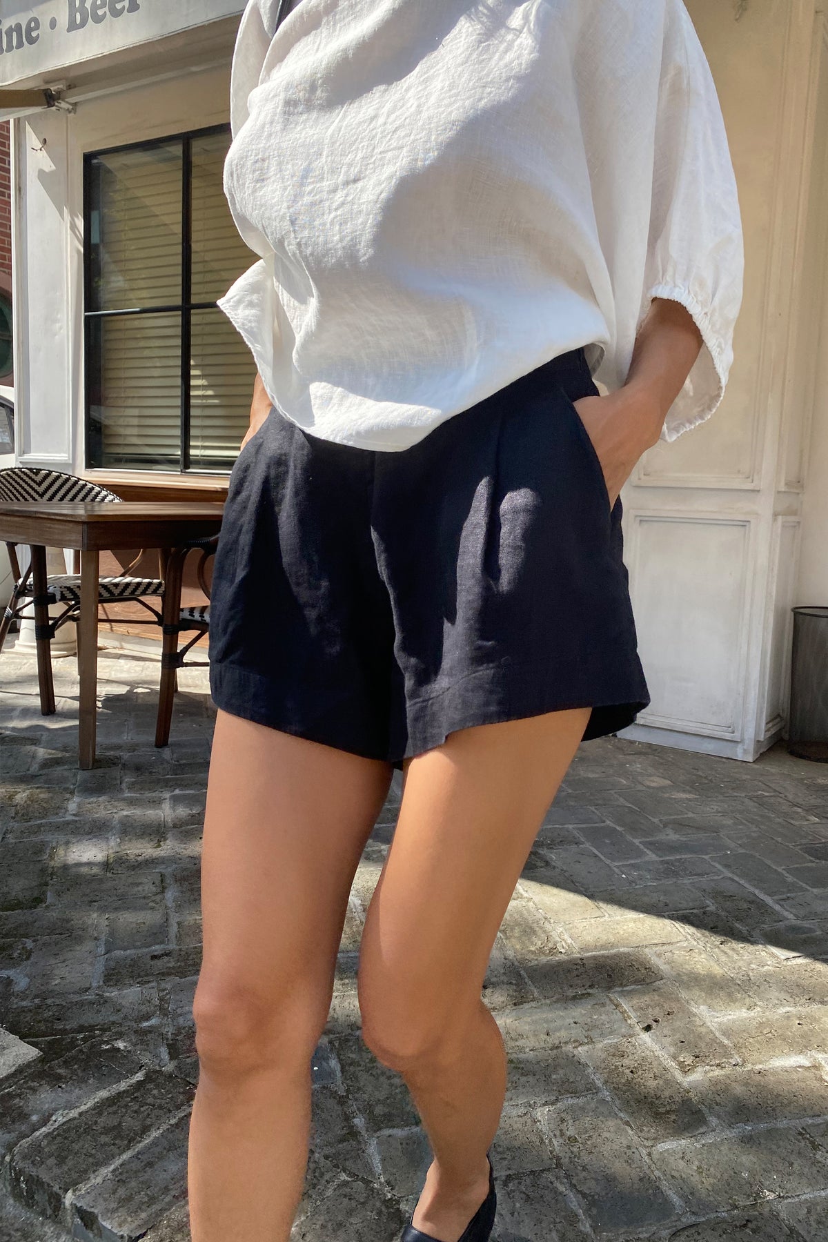 Gaia Linen Shorts in Black - close up front view while walking with Demi ivory linen top - Lilly Pilly Collection