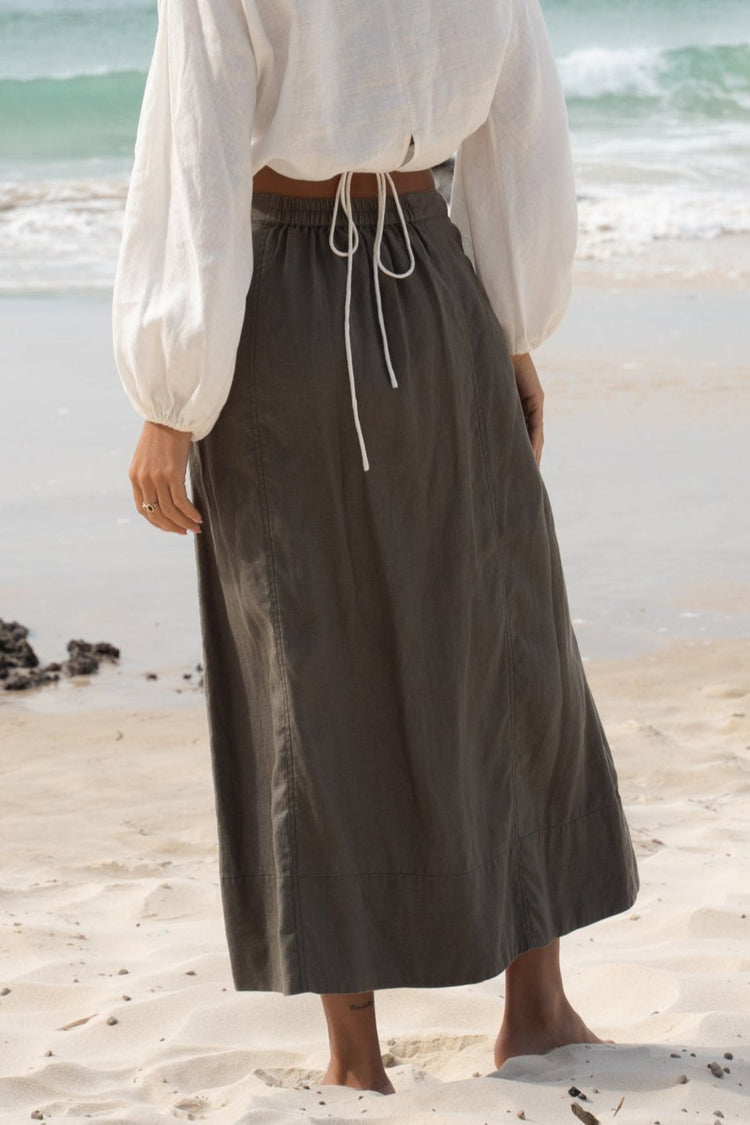 Gia Linen Midi Skirt in Khaki - close-up back view, on the beach - Lilly Pilly Collection