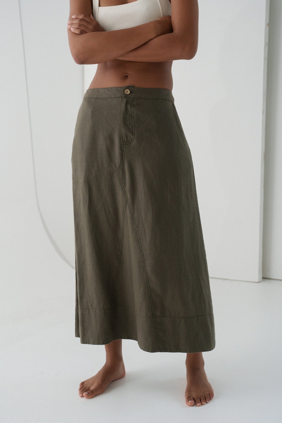 woman wearing  khaki green Gia linen skirt against a white background