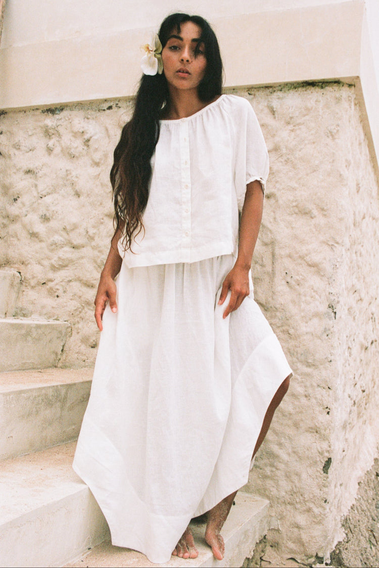 Hannah Linen Maxi Skirt in Ivory - standing on stone steps, elasticated waist and side split, worn with button-front top - Lilly Pilly Collection