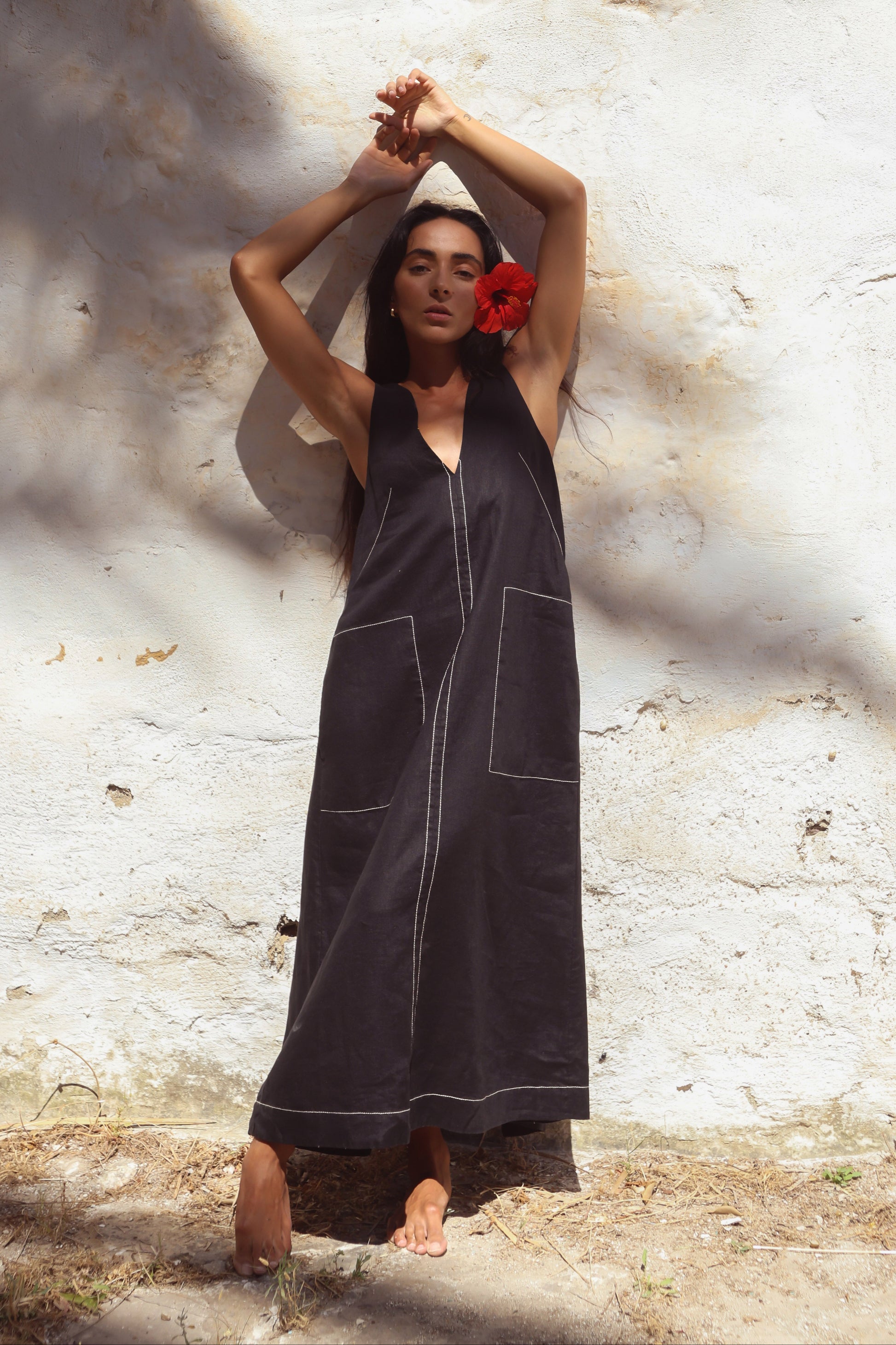 Woman in Iris Linen sleeveless midi dress, black with white contrast stitching, front view - Lilly Pilly Collection