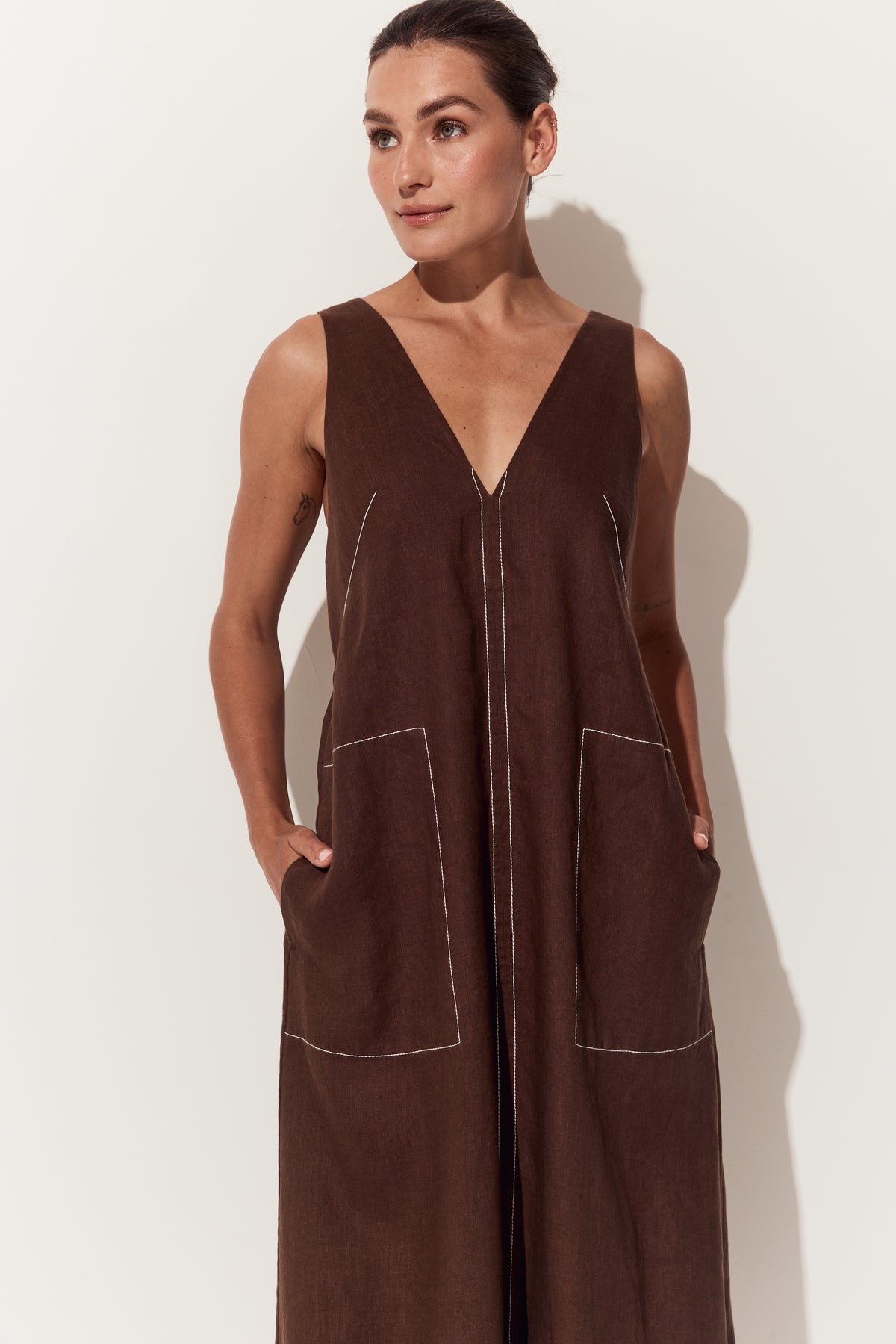 Iris Linen Midi Dress in Chocolate - close up front view of dress with a deep V-neck and hands in large front patch pockets - Lilly Pilly Collection