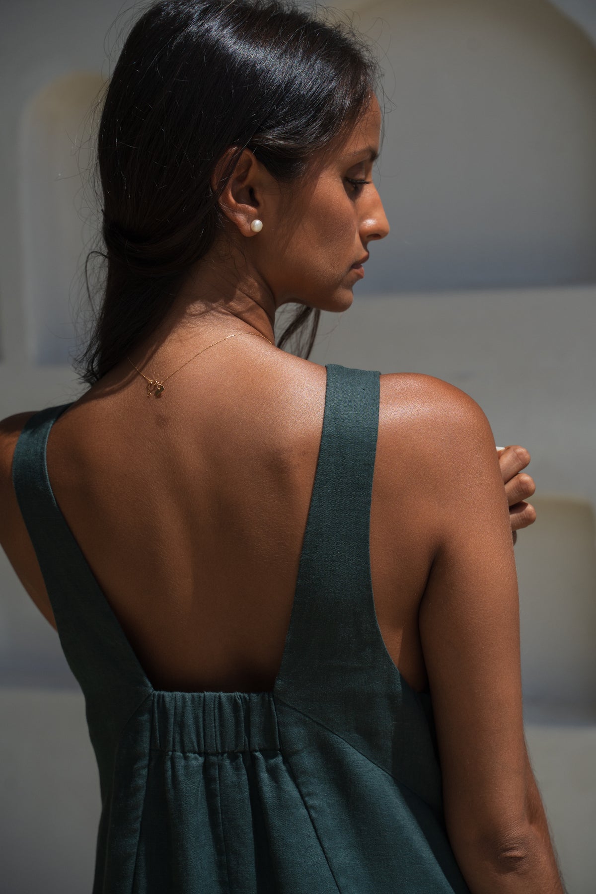 Close up of woman in a forest green LILLY PILLY Iris dress revealing the back design details