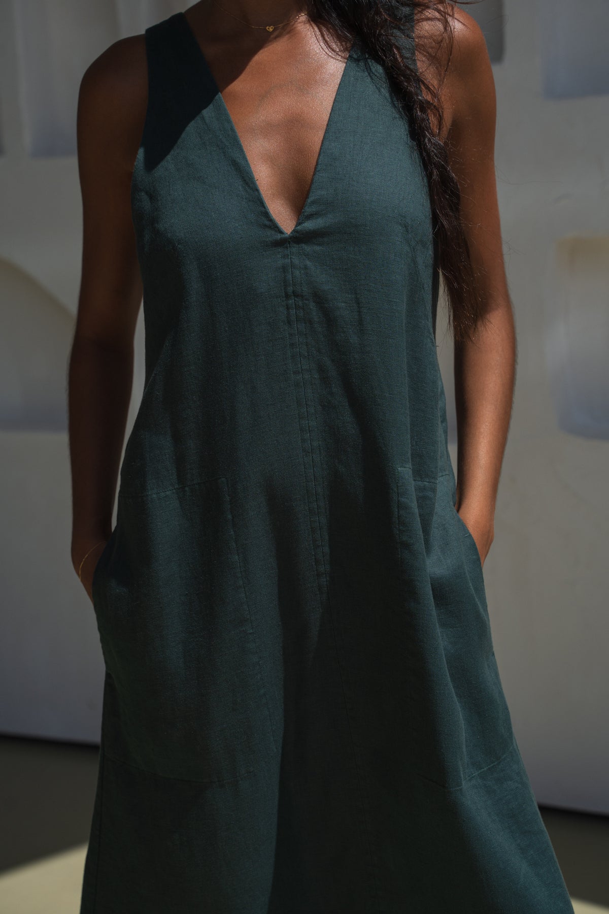 Close up front view of woman in a forest green LILLY PILLY Iris dress against a neutral background