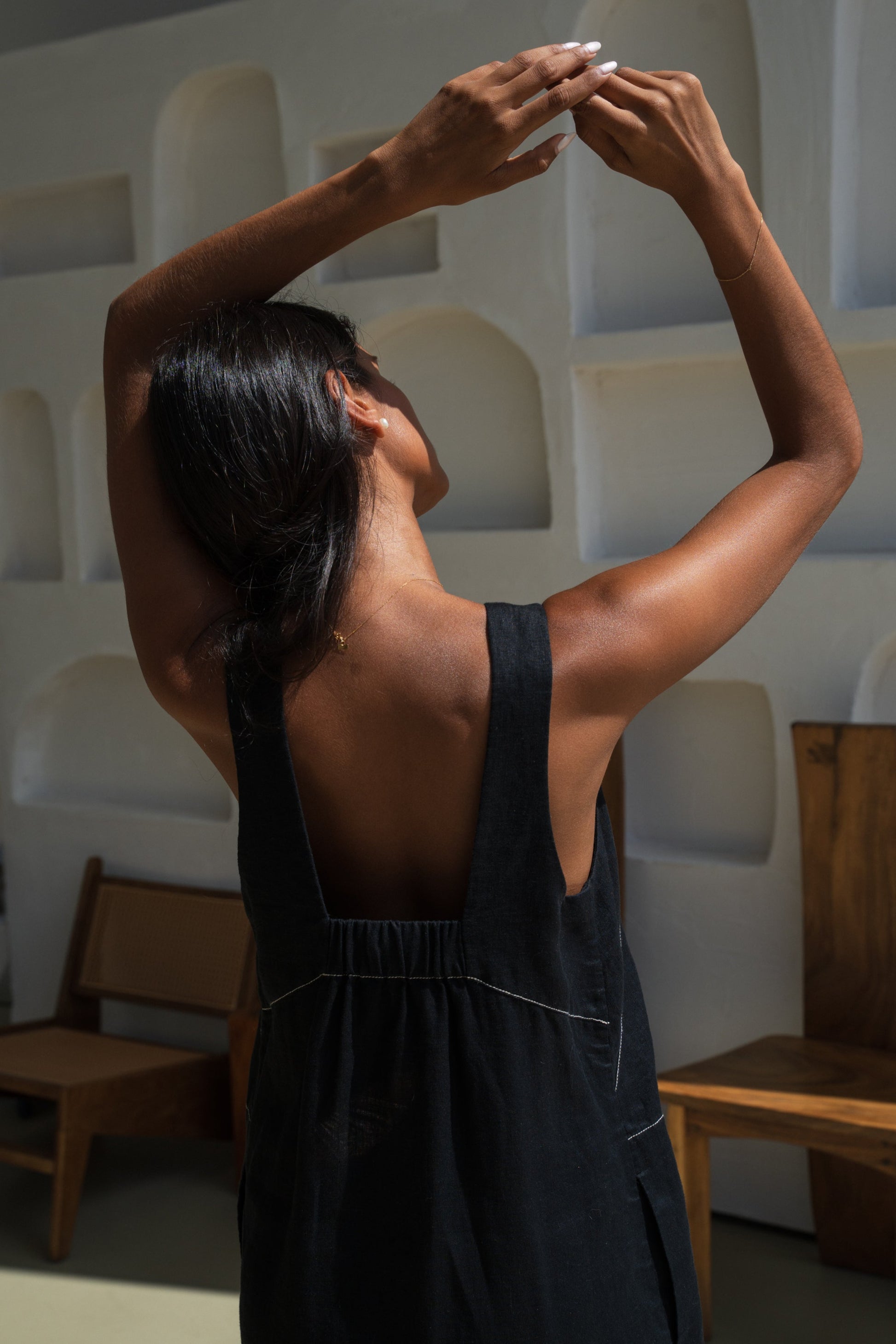 LILLY PILLY woman in an black Isla linen dress with white stitching showing back view details