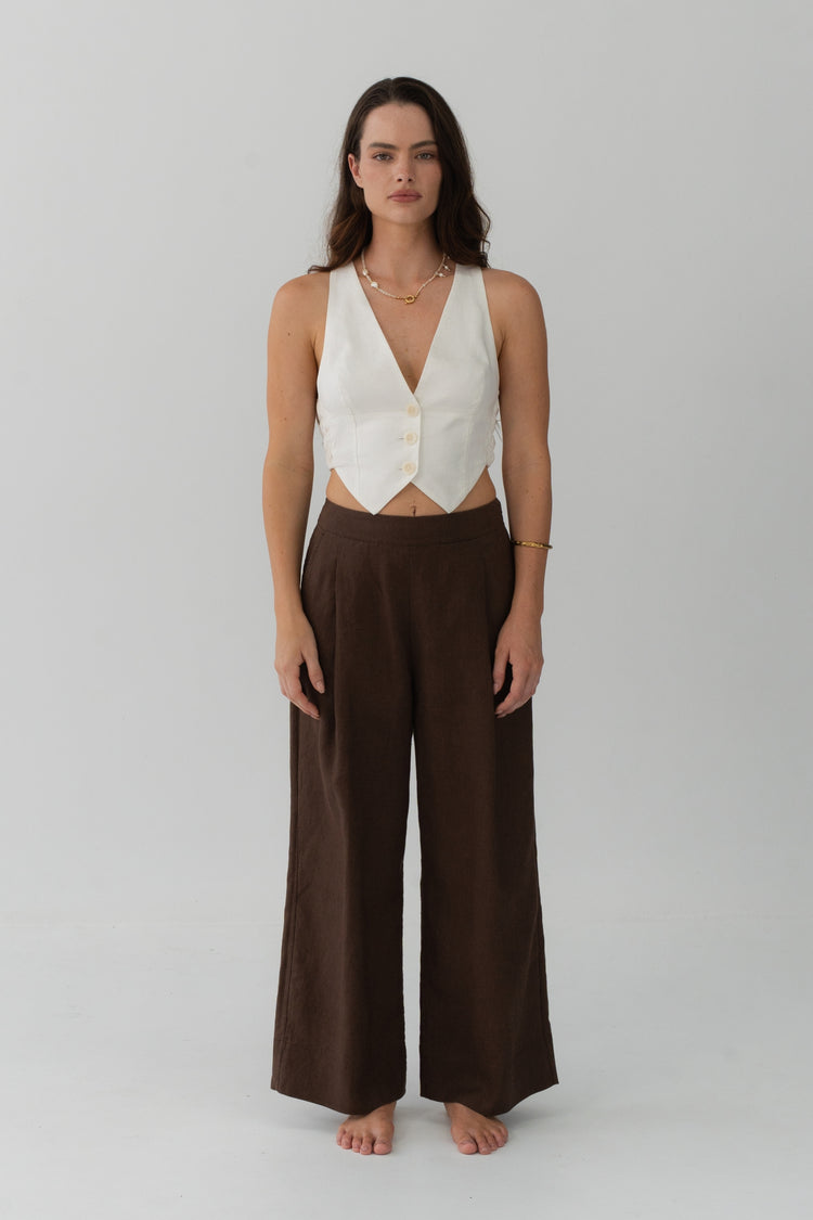 Ivy Linen Crop Pants in Chocolate - full length front view, woman wearing Chocolate wide-leg linen pants with ivory linen waistcoat, studio backdrop - Lilly Pilly Collection