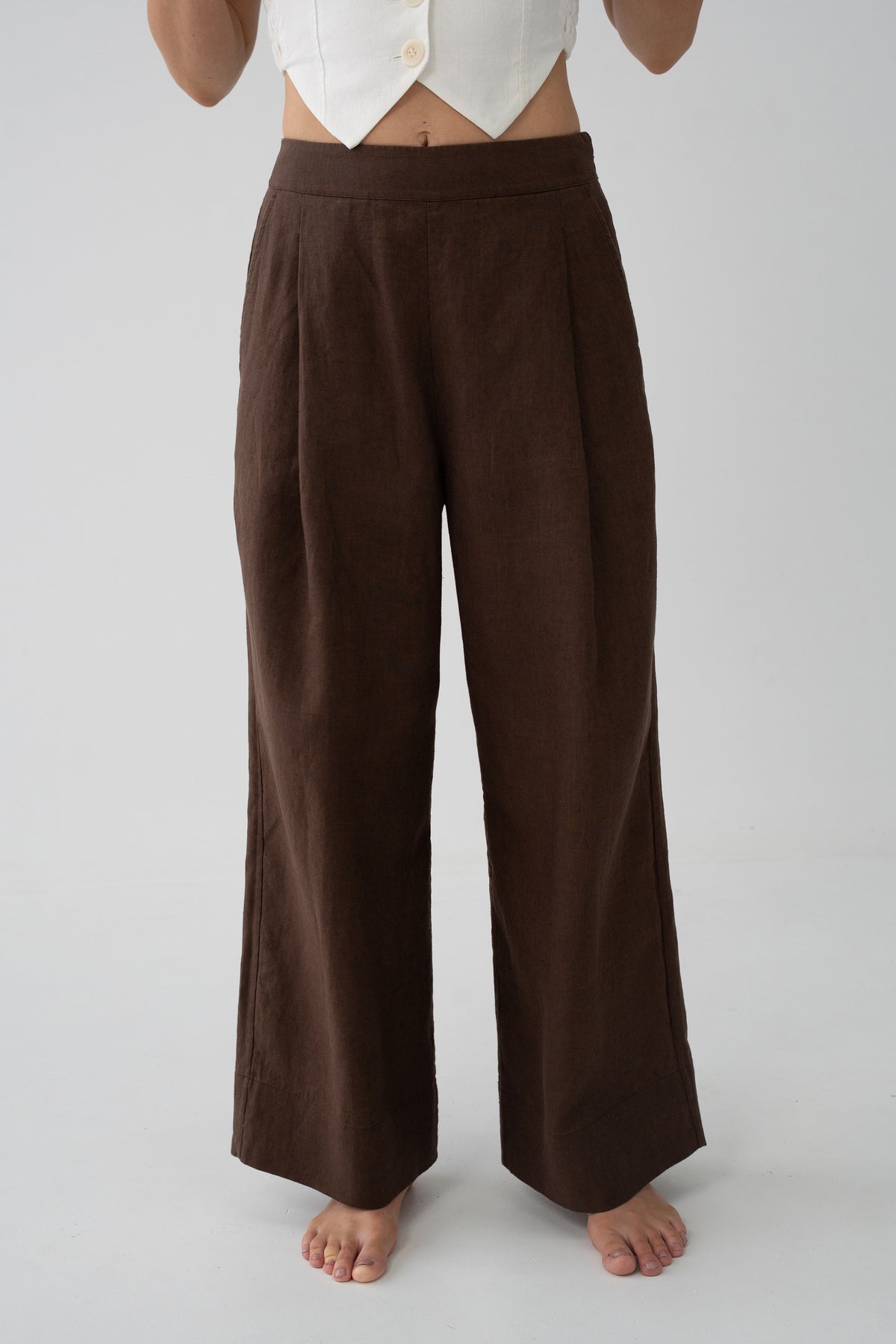 Ivy Linen Crop Pants in Chocolate - close-up of front pleats and flat waistband, wide-leg linen silhouette, studio backdrop - Lilly Pilly Collection