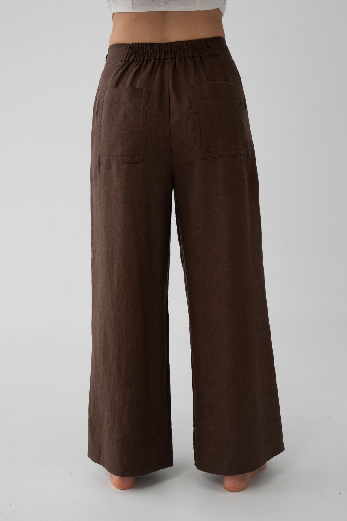 Ivy Linen Crop Pants in Chocolate - back close-up of elasticated waistband and wide-leg linen silhouette, studio backdrop - Lilly Pilly Collection