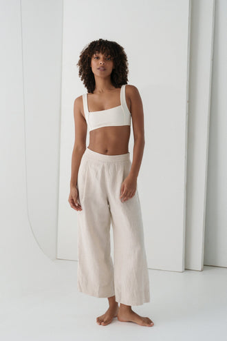 Ivy Linen Crop Pants in Oatmeal - full length front view, woman wearing Oatmeal wide-leg linen crop pants with ivory square-neck crop bra top, white studio backdrop - Lilly Pilly Collection