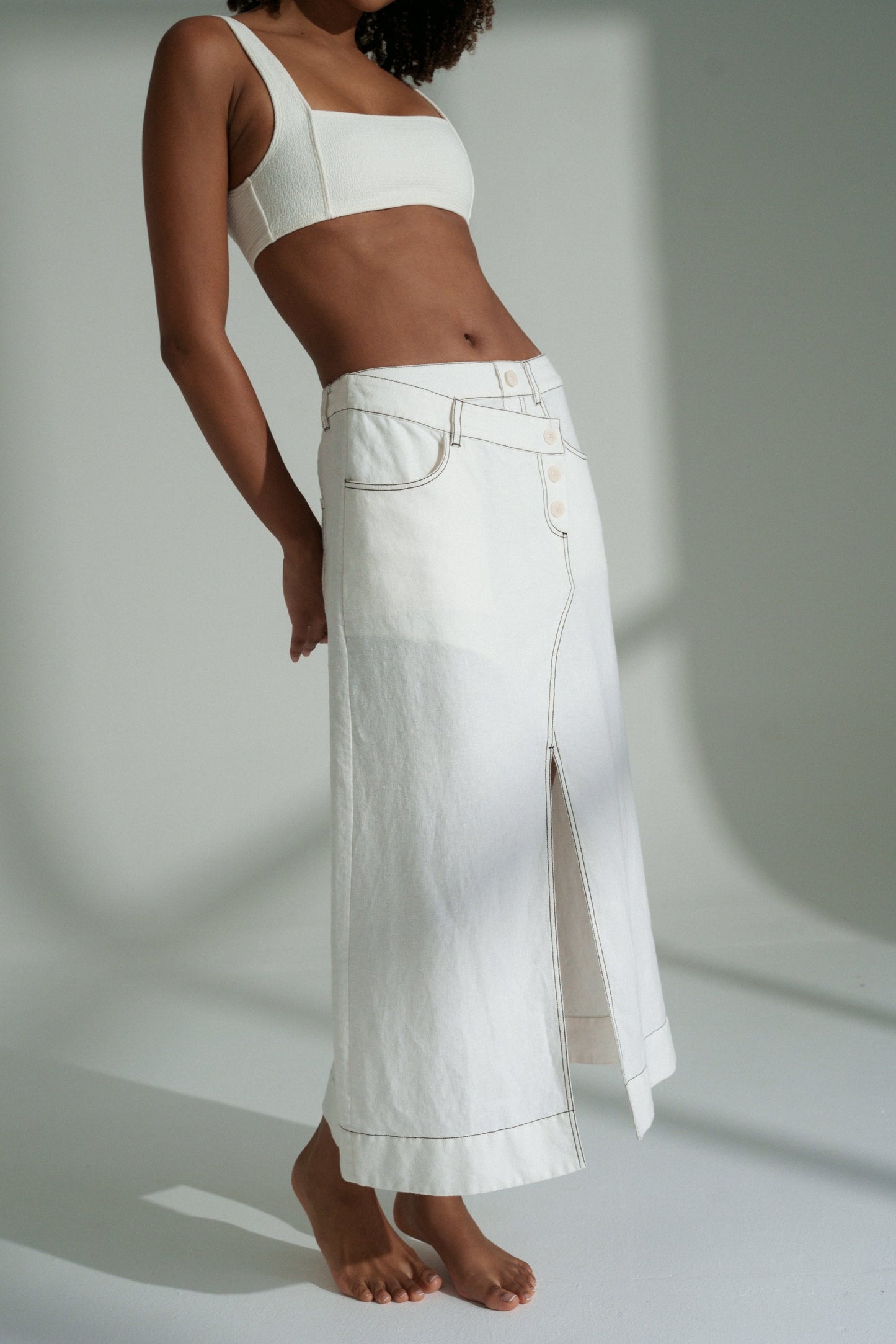 LILLY PILLY woman in a ivory Jax Skirt  on a plain background showing side view