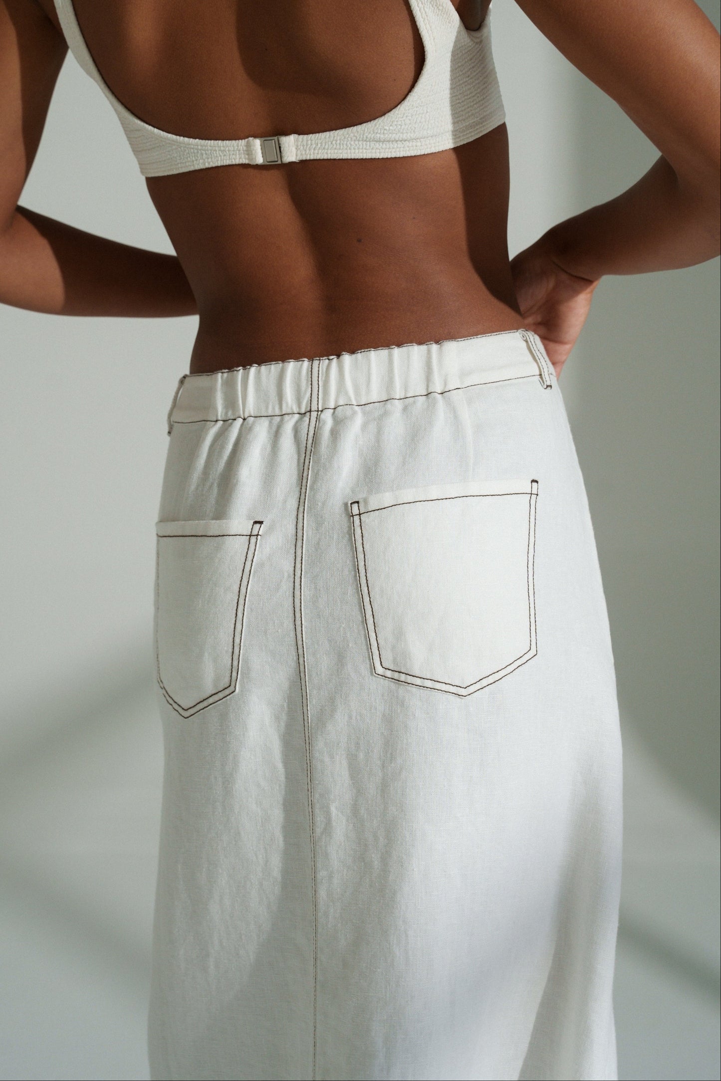 LILLY PILLY woman in a ivory Jax Skirt  against a neutral background showing back pocket view