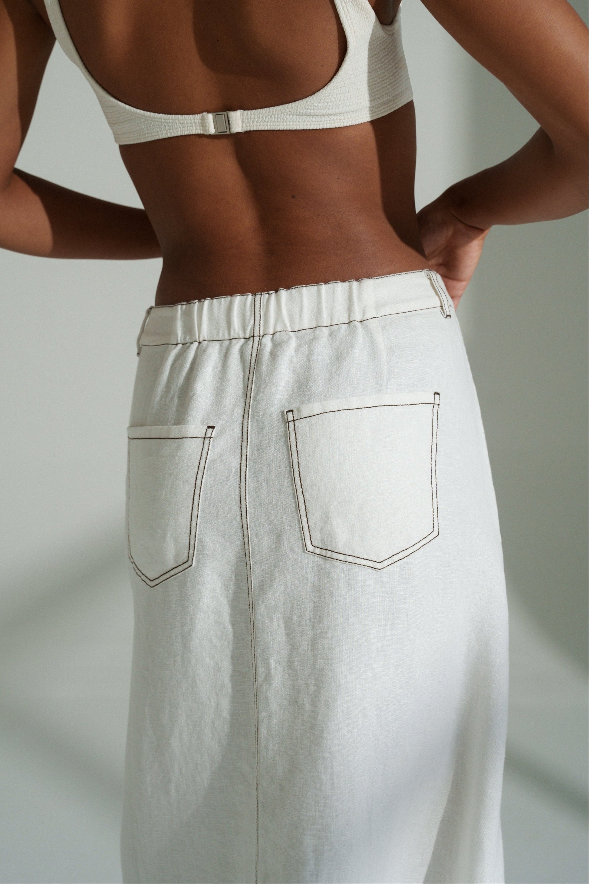 LILLY PILLY woman in a ivory Jax Skirt  against a neutral background showing back pocket view