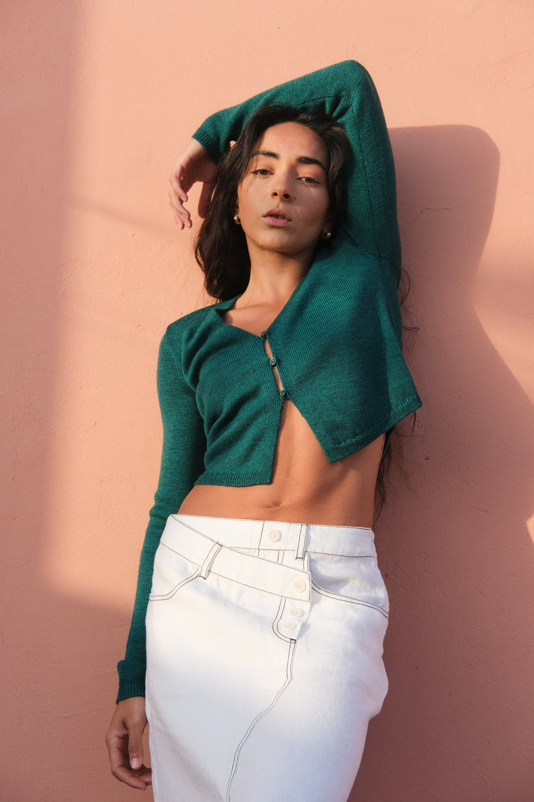 Jax Linen Midi Skirt in Ivory - front view, styled with the Indie merino cardi in forest green, pink wall background - Lilly Pilly Collection