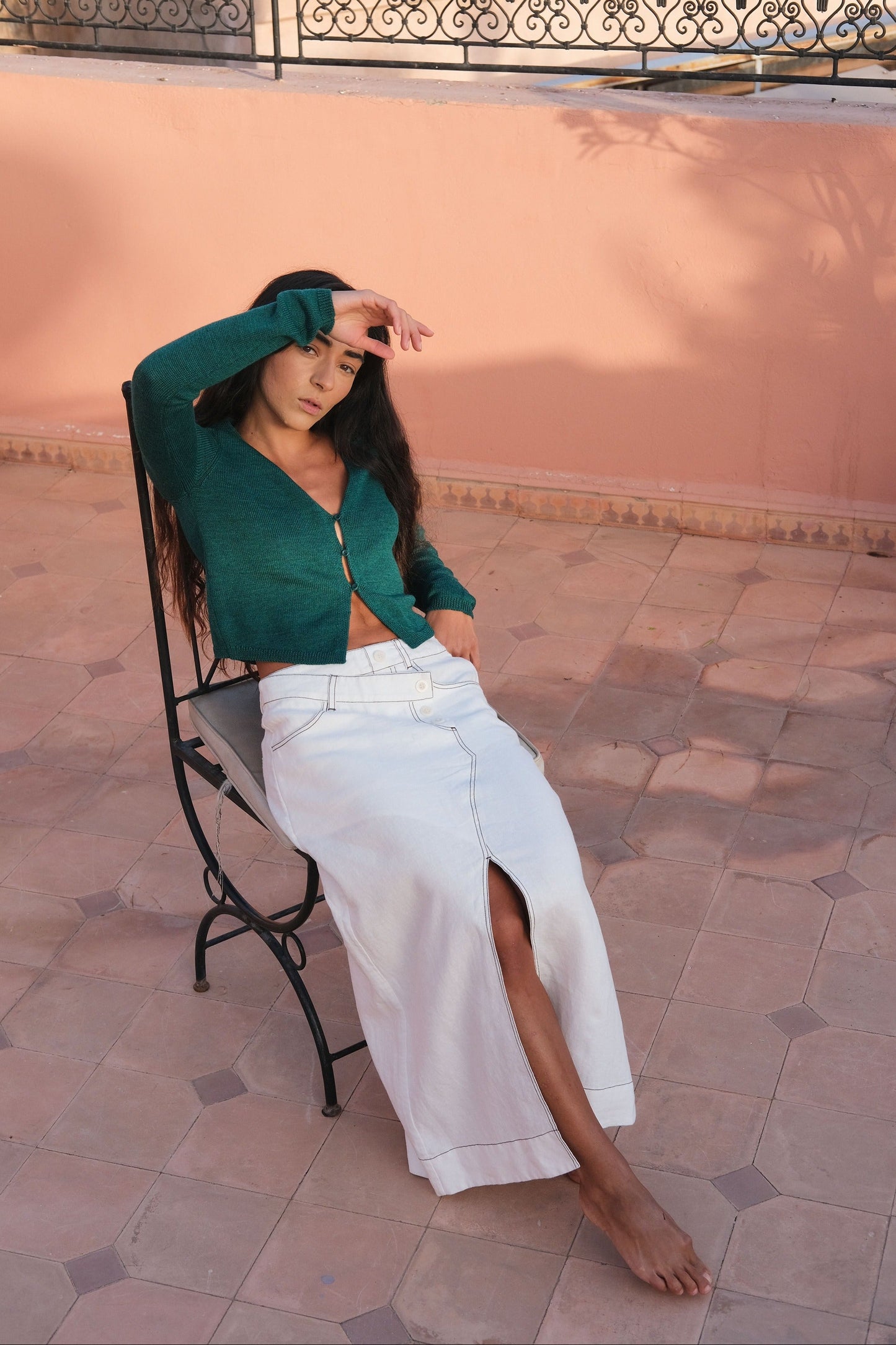 LILLY PILLY woman in a ivory Jax Skirt and a forest green cropped Indie merino cardi in an outdoor setting.