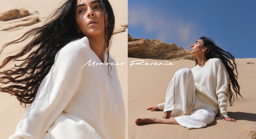 LILLY PILLY woman wearing June cashmere knit in ivory while sitting in the sand dunes