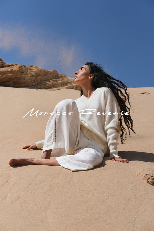 LILLY PILLY woman wearing June cashmere knit in ivory while sitting in the sand dunes