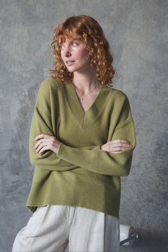 June Cashmere Knit in Olive - side profile, arms crossed, worn with Oli Linen Pants in Ivory, studio setting - Lilly Pilly Collection