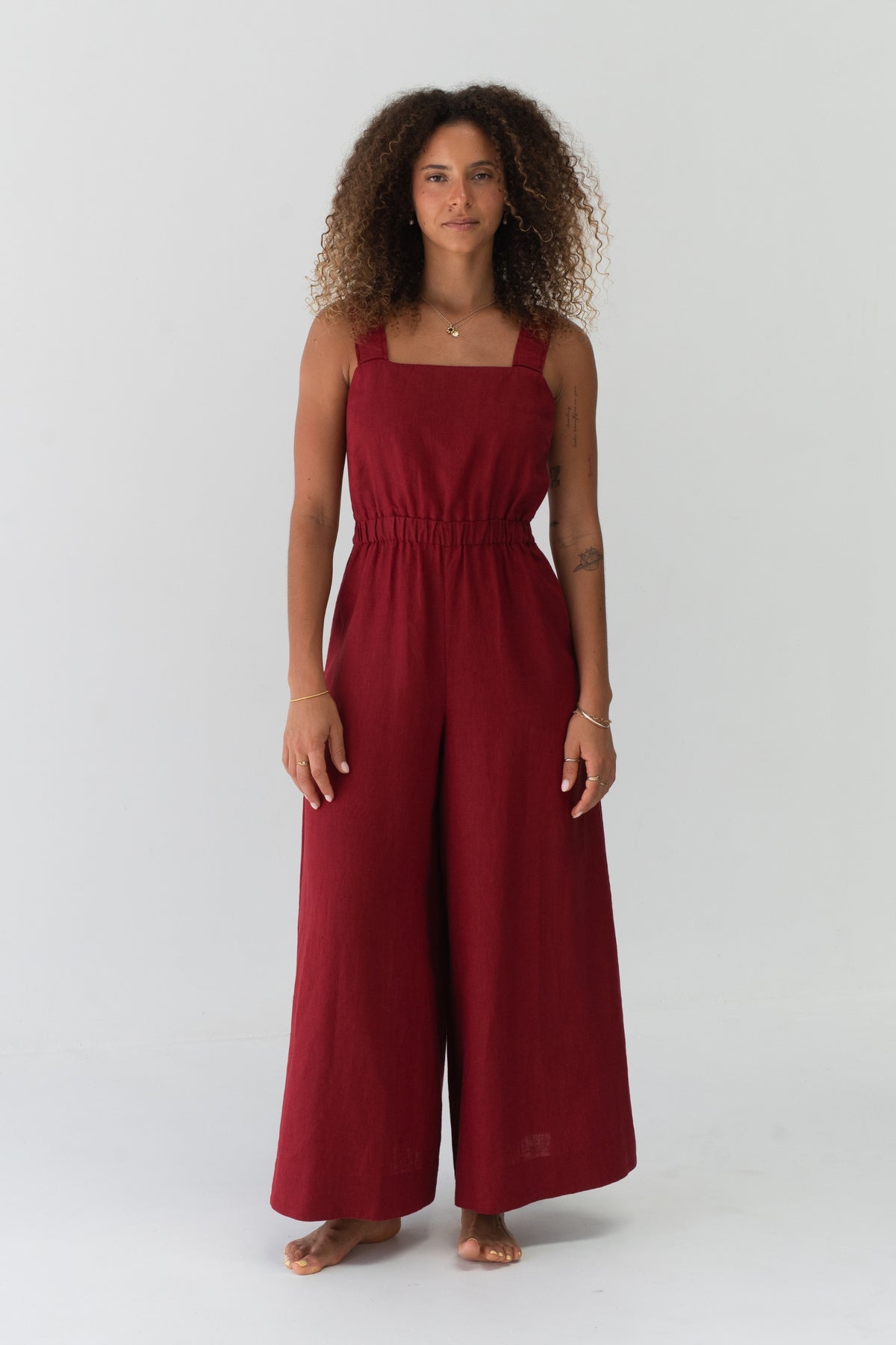 Front view of a woman wearing the Keely Linen jumpsuit in Cherry Red in a studio setting - Lilly Pilly Collection