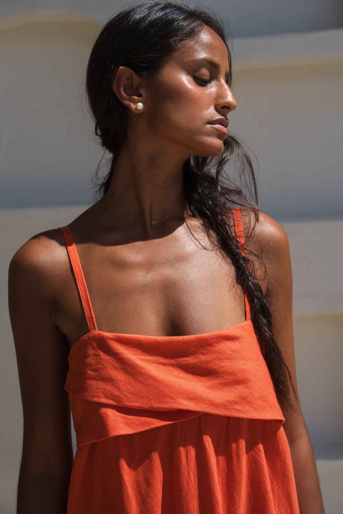 close up view of lilly pilly woman in a spritz coloured Kiko linen dress standing with a neutral background