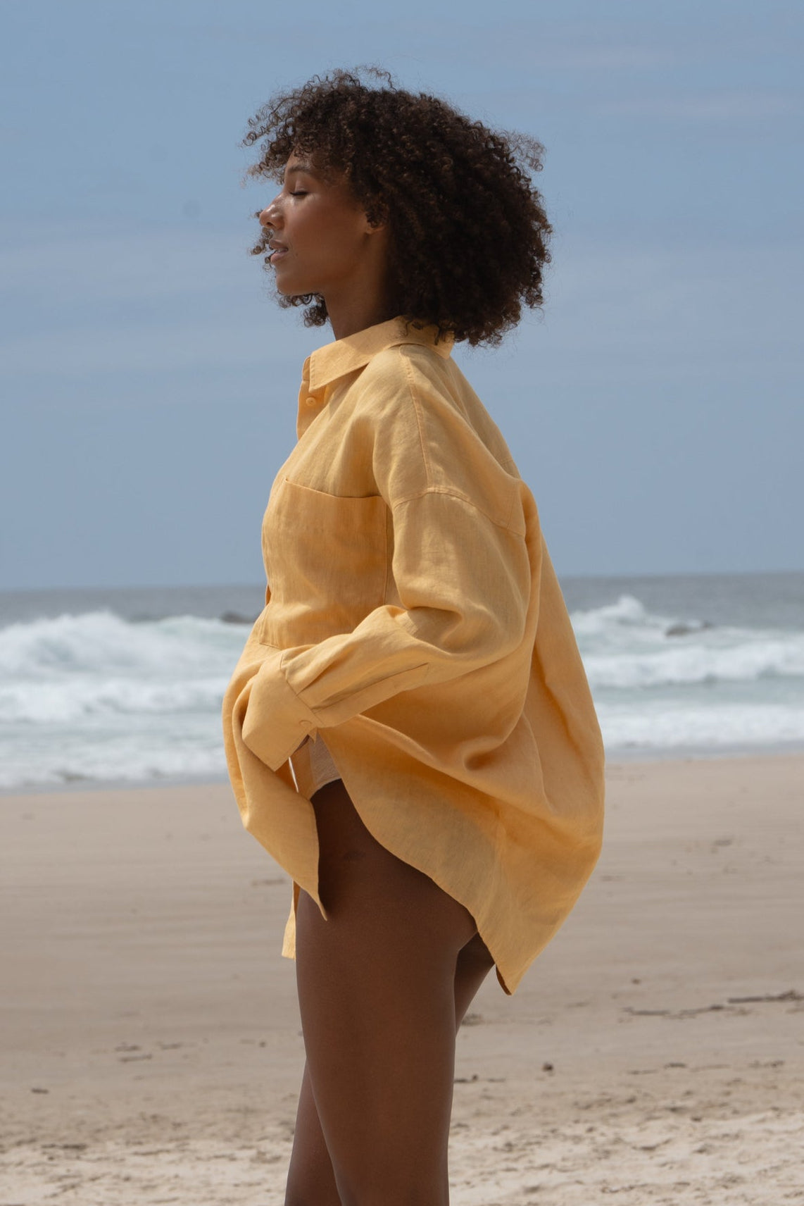 Lilly Pilly Collection Kirra shirt made from European  linen in Butter side view on the beach