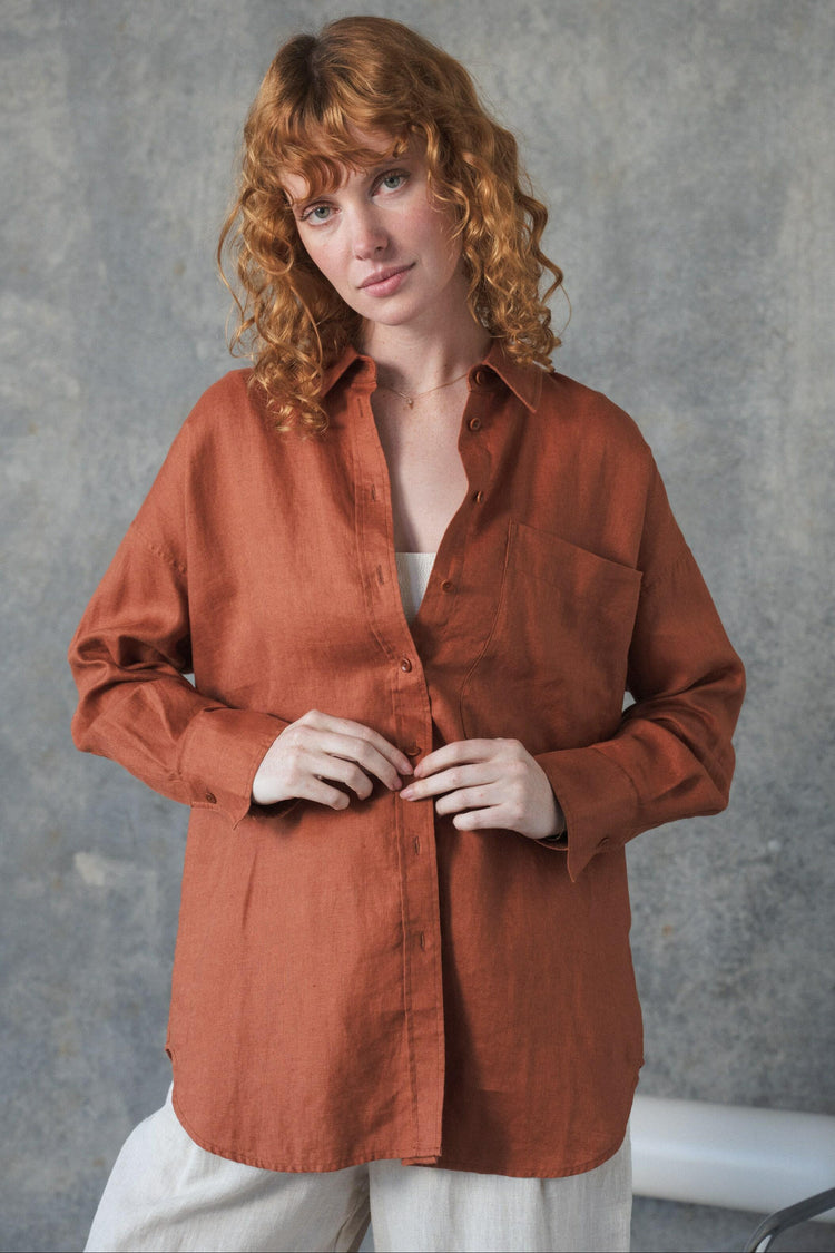 Kirra Linen Shirt in Cajun Red - front view, collared button-front and patch pocket, buttoning, worn with wide-leg trousers, studio setting - Lilly Pilly Collection