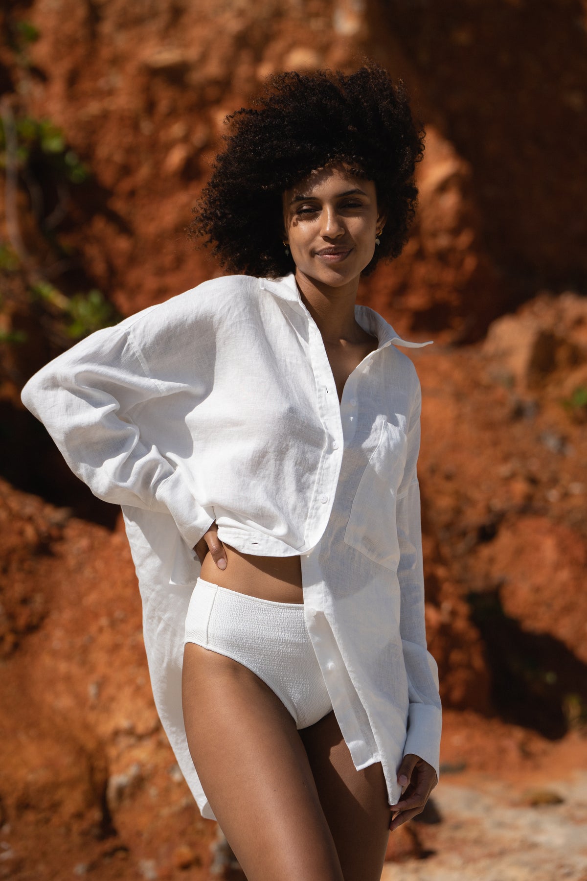 Lilly Pilly Collection Kirra shirt made from European linen in Ivory front view standing by a red rock