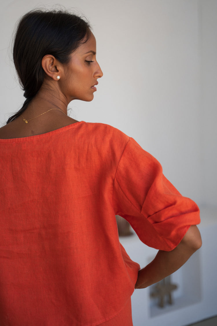 Leia Linen Top in Spritz Orange - close-up back view, puff sleeve detail, worn with matching pants, studio setting - Lilly Pilly Collection