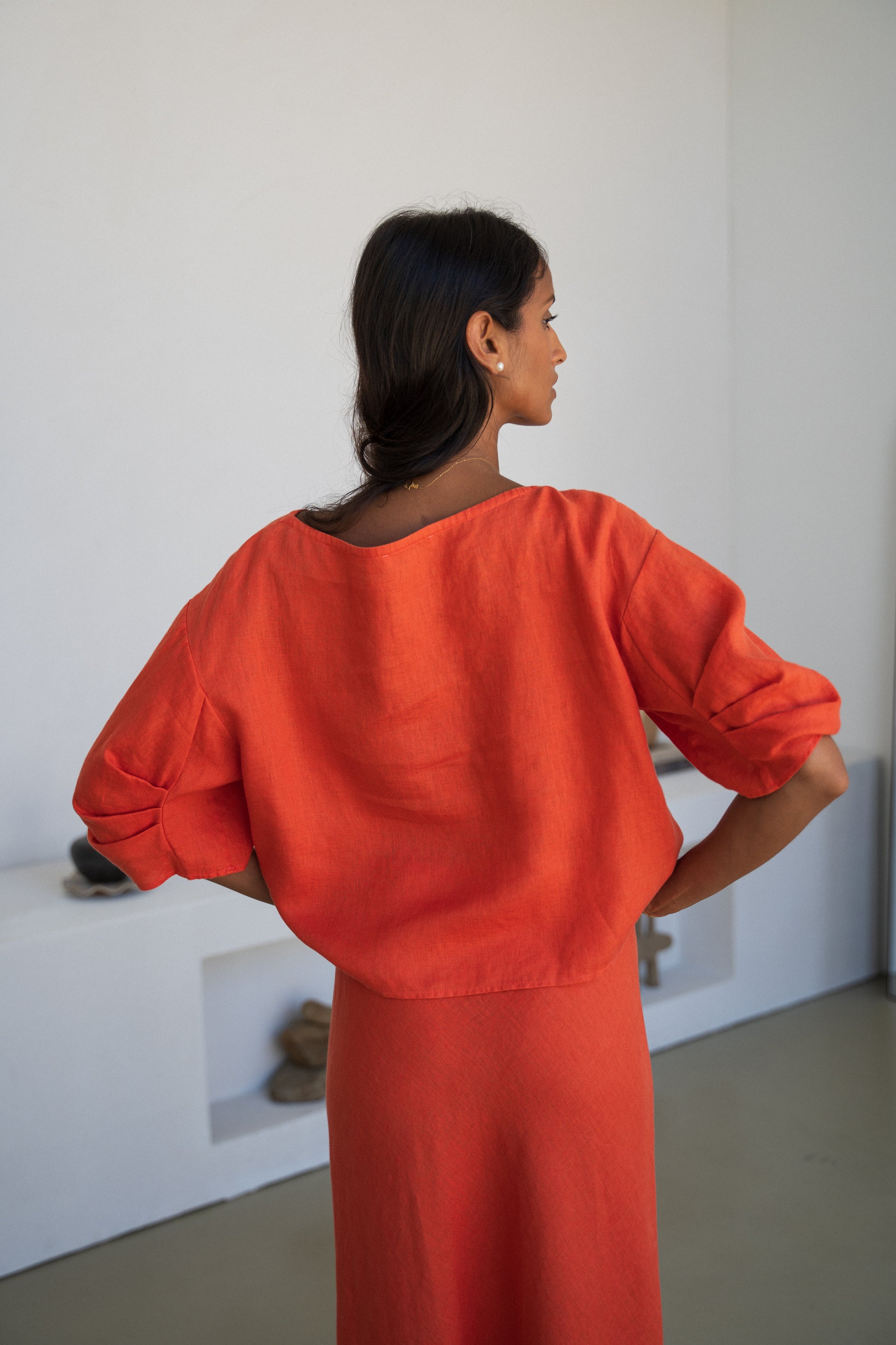 LILLY PILLY woman wearing Leia linen top in Spritz paired with Riley linen skirt back view