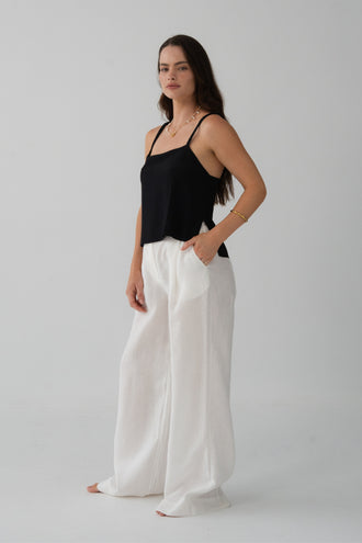Leni Silk Cami in Black - three-quarter view, square neckline and thin straps, worn with Oli Pants in Ivory, hand in pocket - Lilly Pilly Collection