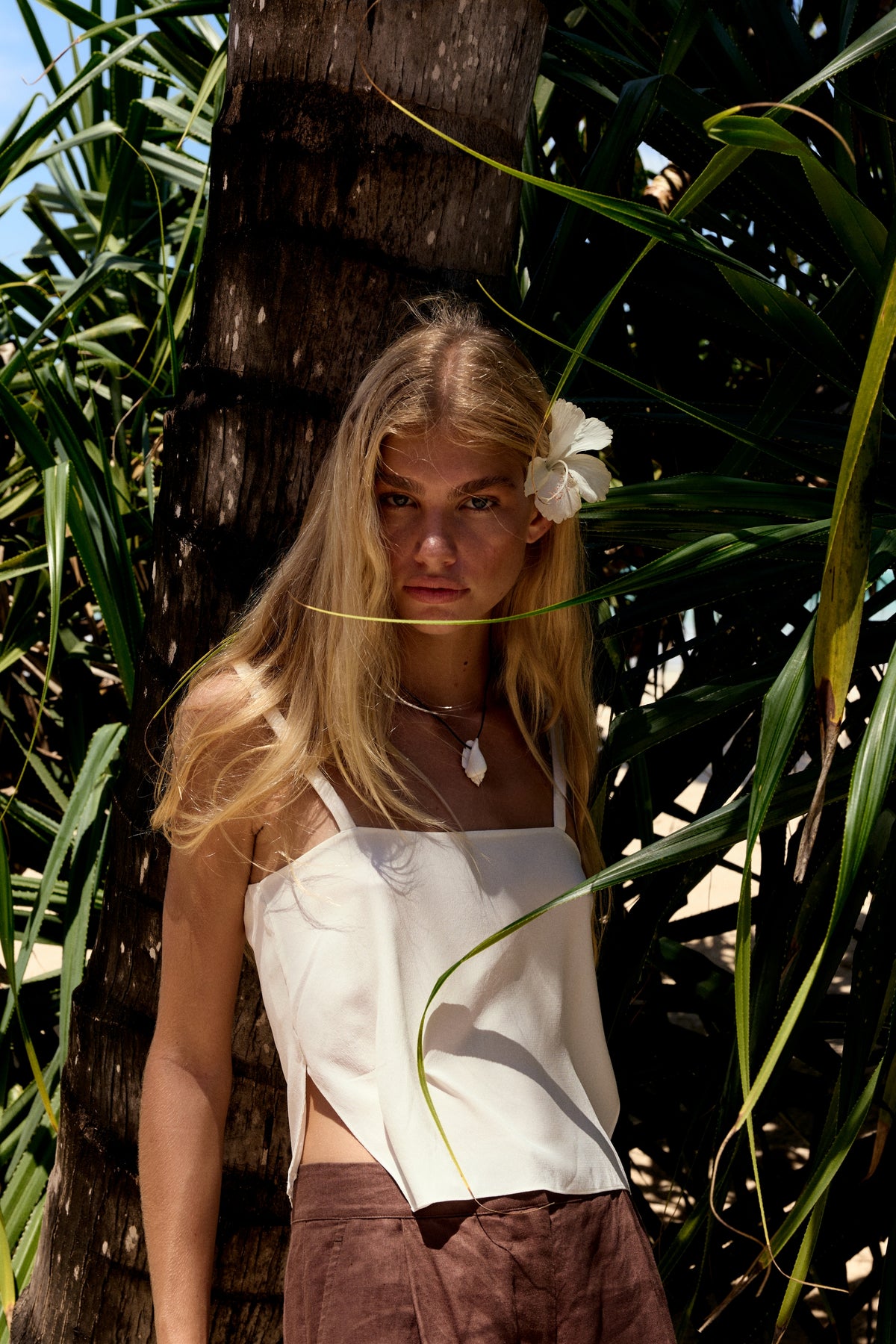 Leni Silk Cami in Ivory - close-up, square neckline and thin straps, hibiscus flower, textured wall backdrop - Lilly Pilly Collection