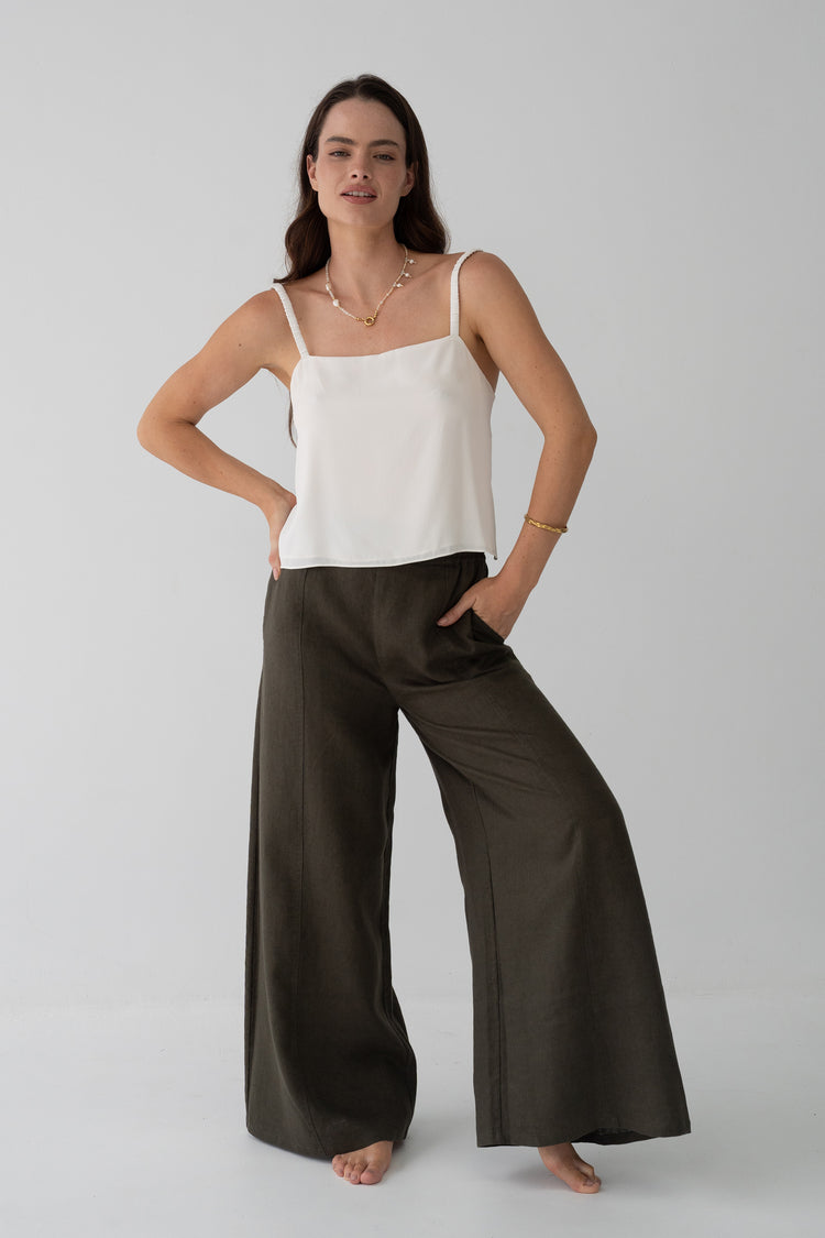 Letty Linen Pants in Khaki - front view, woman wearing Khaki wide-leg linen pants with ivory silk cami, studio backdrop - Lilly Pilly Collection