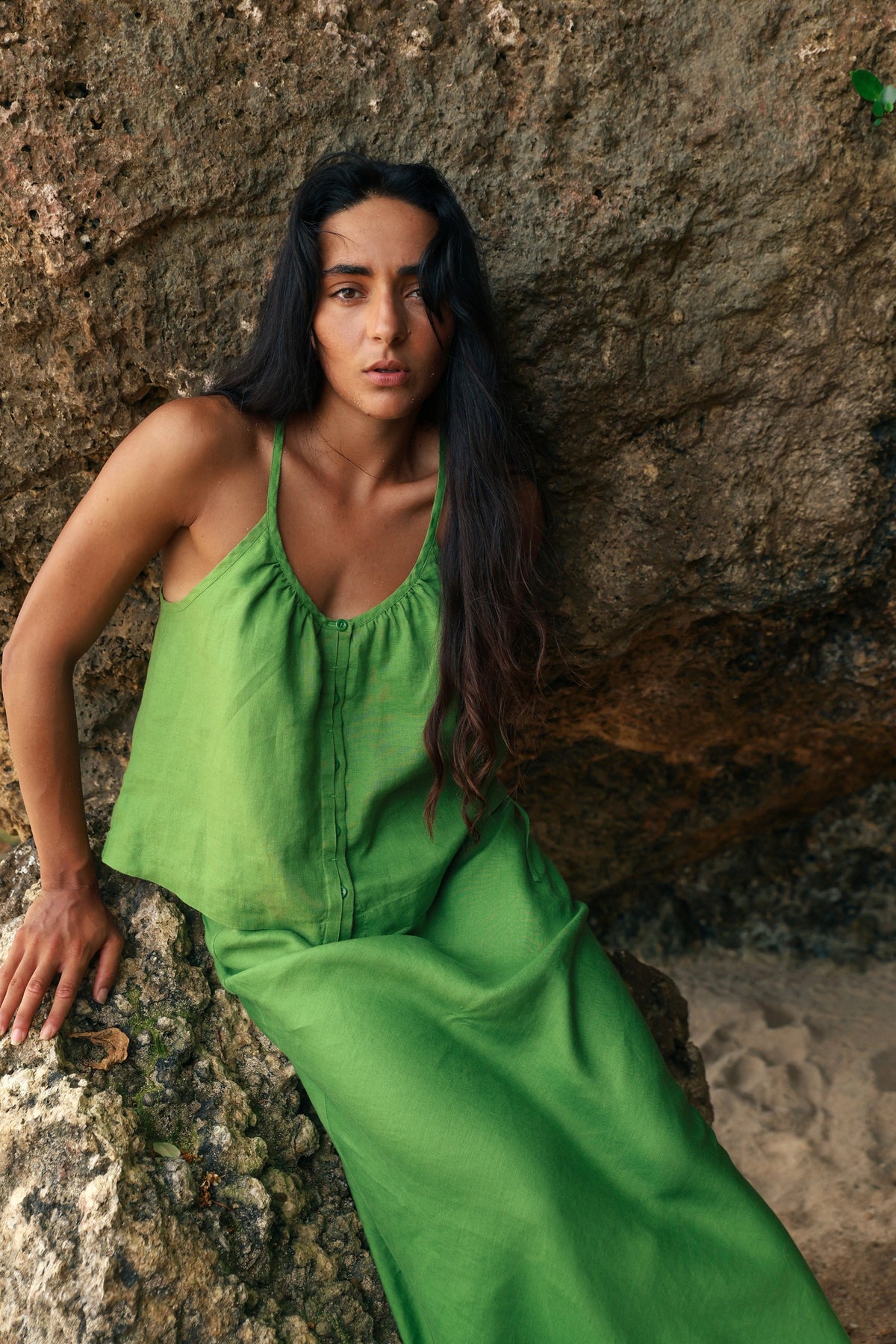 Lola Linen Cami in Lime Green - woman seated on rock, gathered scoop neckline and button-front, styled with matching Riley Linen Maxi Skirt, sandstone backdrop - Lilly Pilly Collection