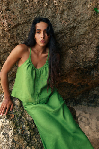 Lola Linen Cami in Lime Green - woman seated on rock, gathered scoop neckline and button-front, styled with matching Riley Linen Maxi Skirt, sandstone backdrop - Lilly Pilly Collection