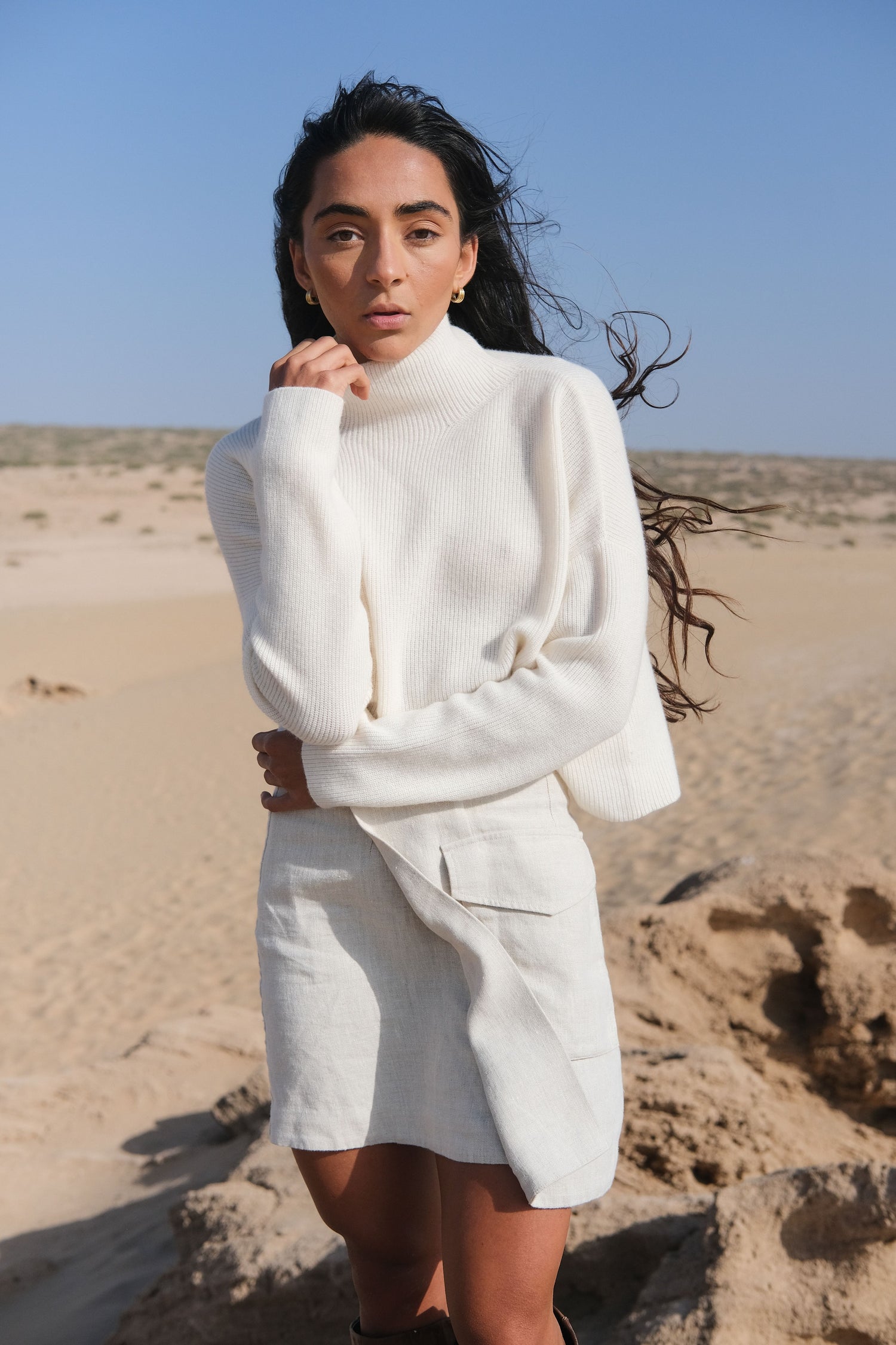 LILLY PILLY Lumi cashmere knit in Ivory standing in a desert landscape