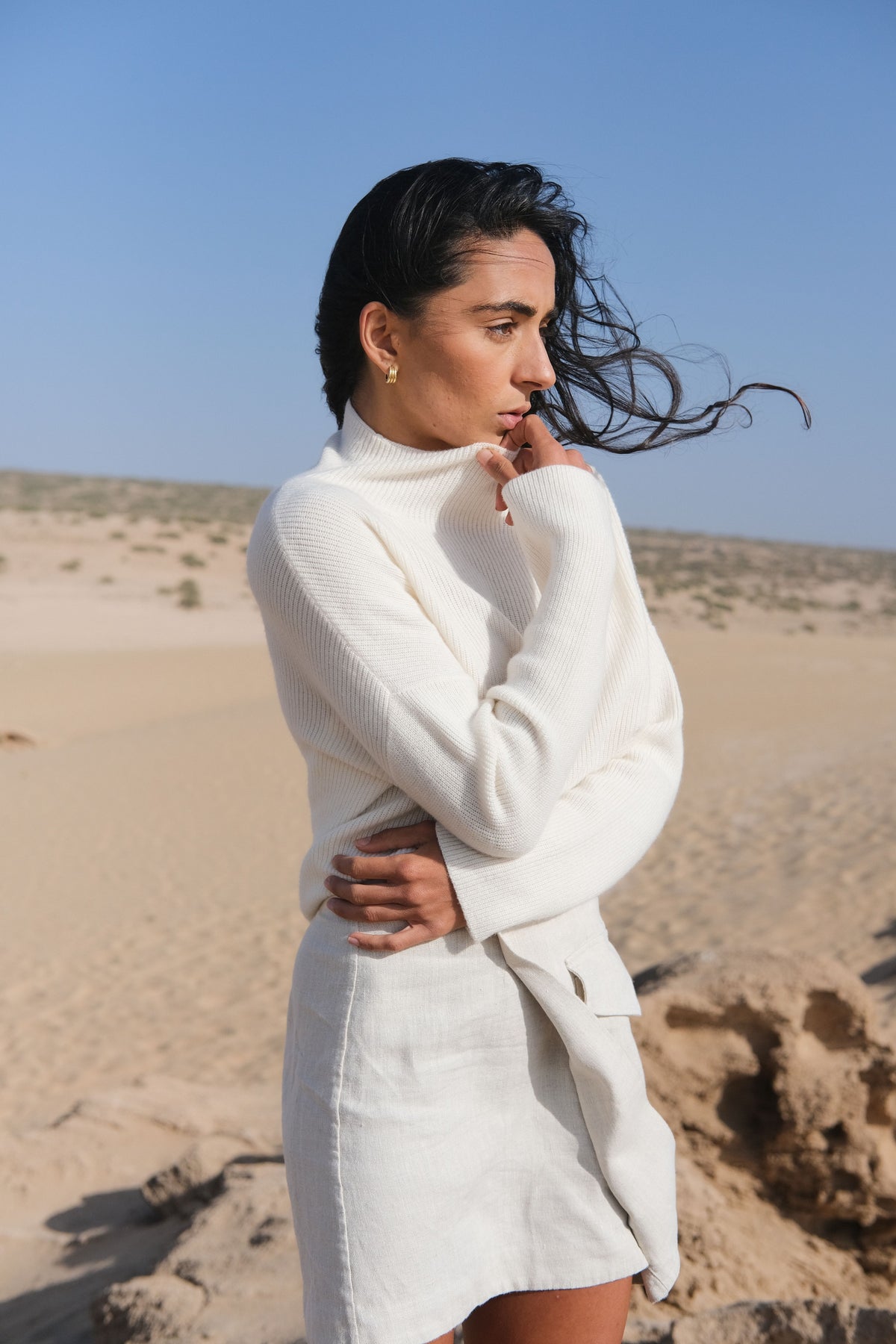 LILLY PILLY Lumi cashmere knit in Ivory standing in a desert landscape