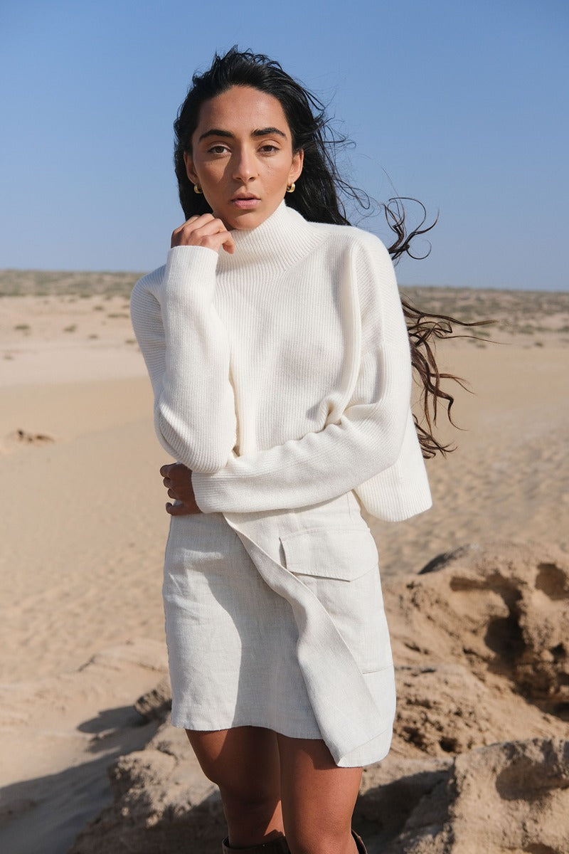 LILLY PILLY Lumi cashmere knit in Ivory standing in a desert landscape