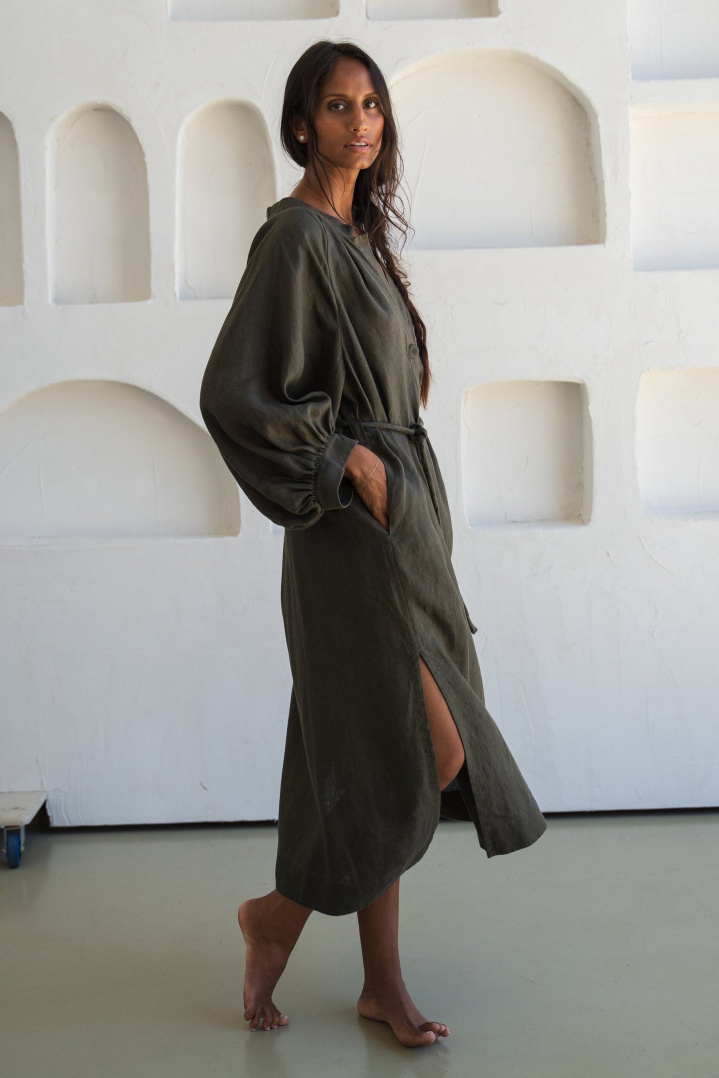 Woman wearing a khaki Mae linen dress in studio