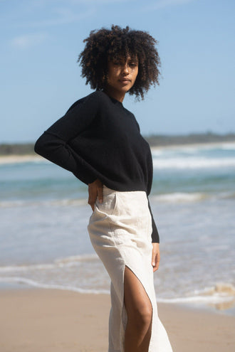 Miri Cashmere Knit in Black - three quarter view while standing on the beach - Lilly Pilly Collection