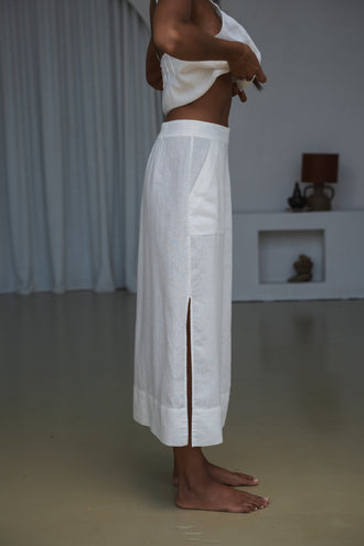 Nadi Linen Midi Skirt in Ivory - close-up side view, minimal indoor setting - Lilly Pilly Collection
