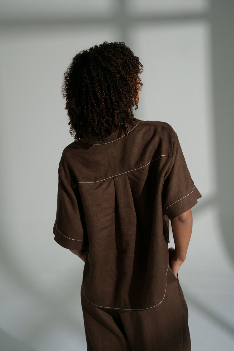 Nika Linen Shirt in Chocolate - back view, light grey wall background - Lilly Pilly Collection