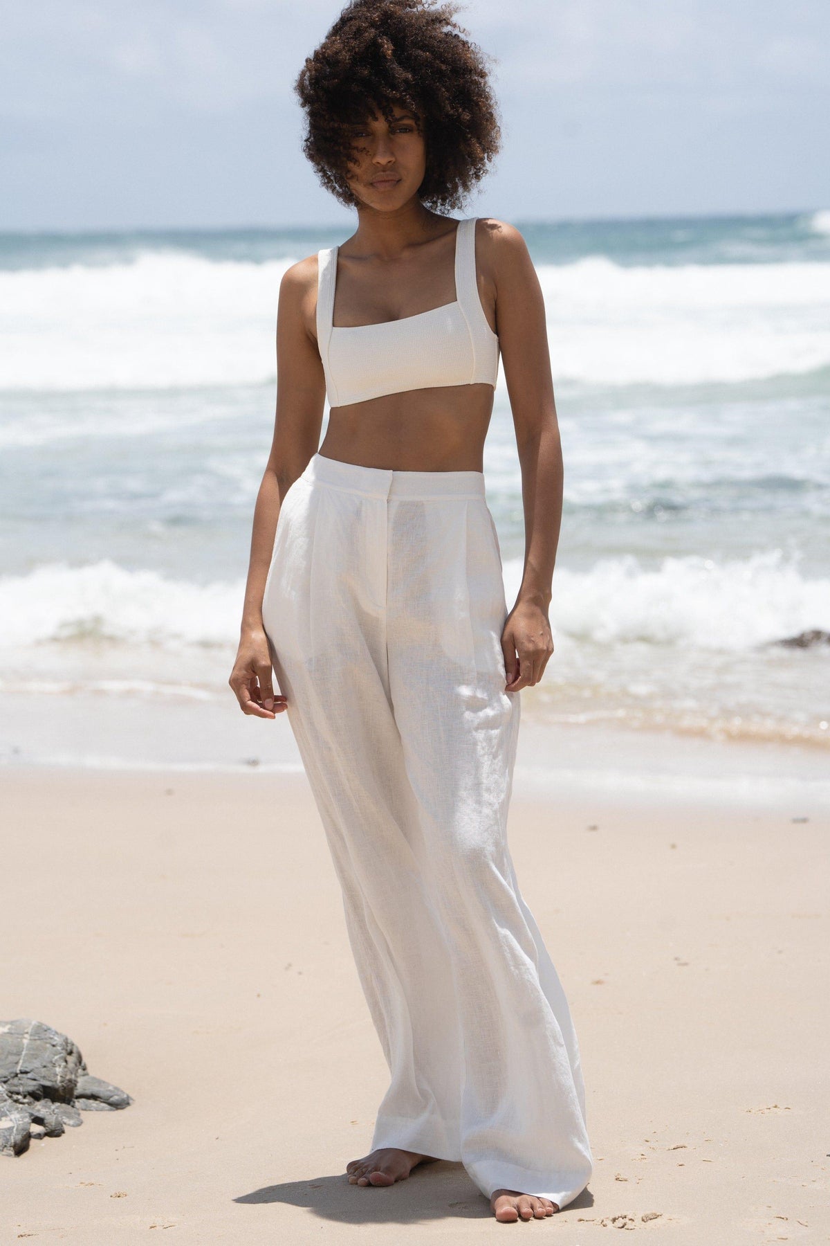 LILLY PILLY Oli linen pants in Ivory full body view on the waters edge