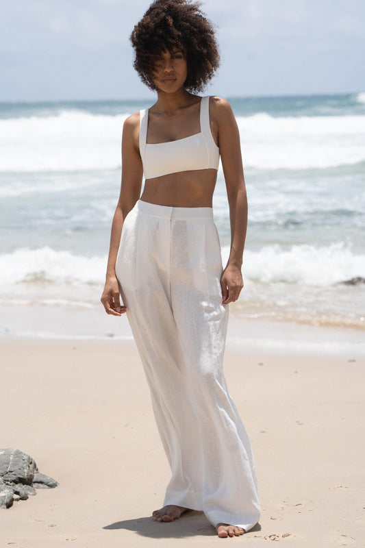 LILLY PILLY Oli linen pants in Ivory full body view on the waters edge