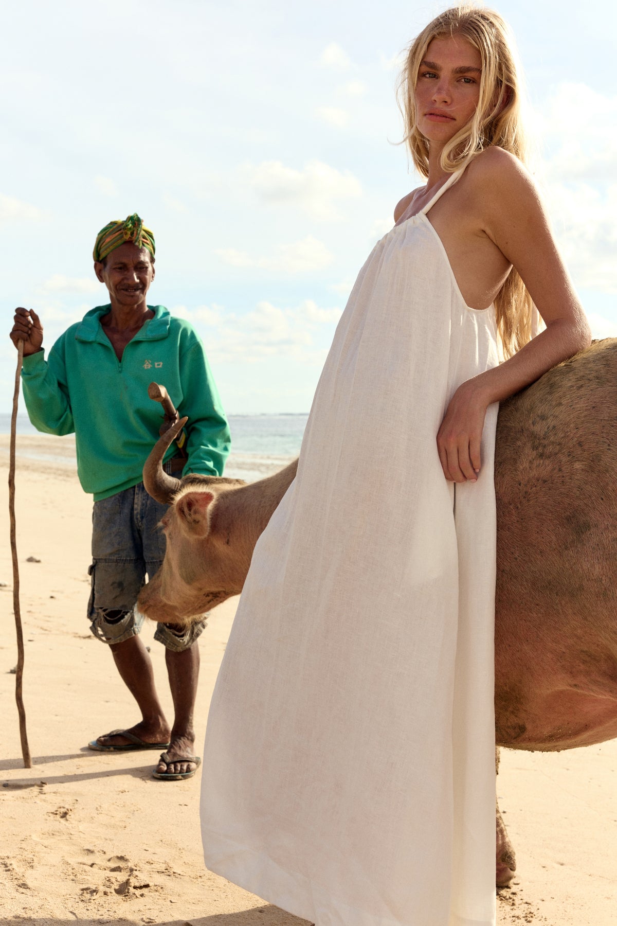 Ophelia Linen Midi Dress in Ivory - side view, open back and spaghetti straps, beach with cattle backdrop - Lilly Pilly Collection