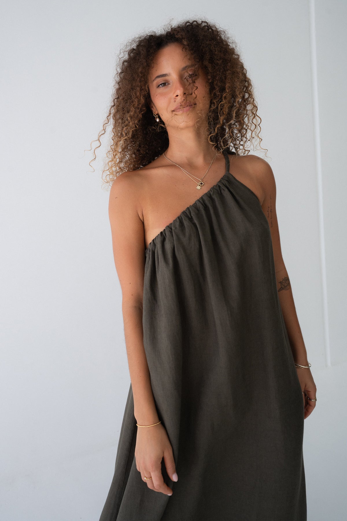 Ophelia Linen Midi Dress in Khaki - three-quarter view, asymmetric neckline and voluminous A-line midi - Lilly Pilly Collection