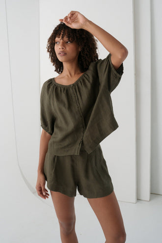 Pia Linen Top in Khaki - arm raised, gathered scoop neckline and button-front, styled with matching Gaia Linen Shorts - Lilly Pilly Collection