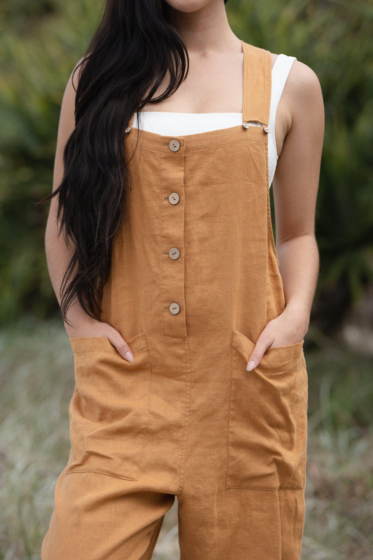 Piper Linen Jumpsuit in Nutmeg Orange - close up front view standing in the grassy sand dunes - Lilly Pilly Collection