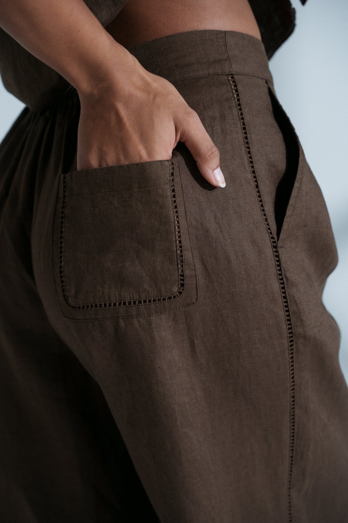 LILLY PILLY woman wearing Rika linen pants in chocolate brown showing close up of pocket detail