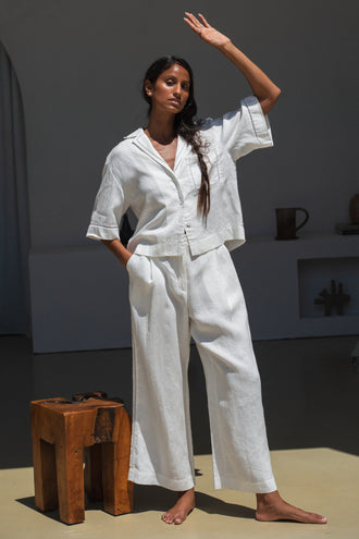 Rika Linen Pants in Ivory - front view with hands shading face from the sun - Lilly Pilly Collection