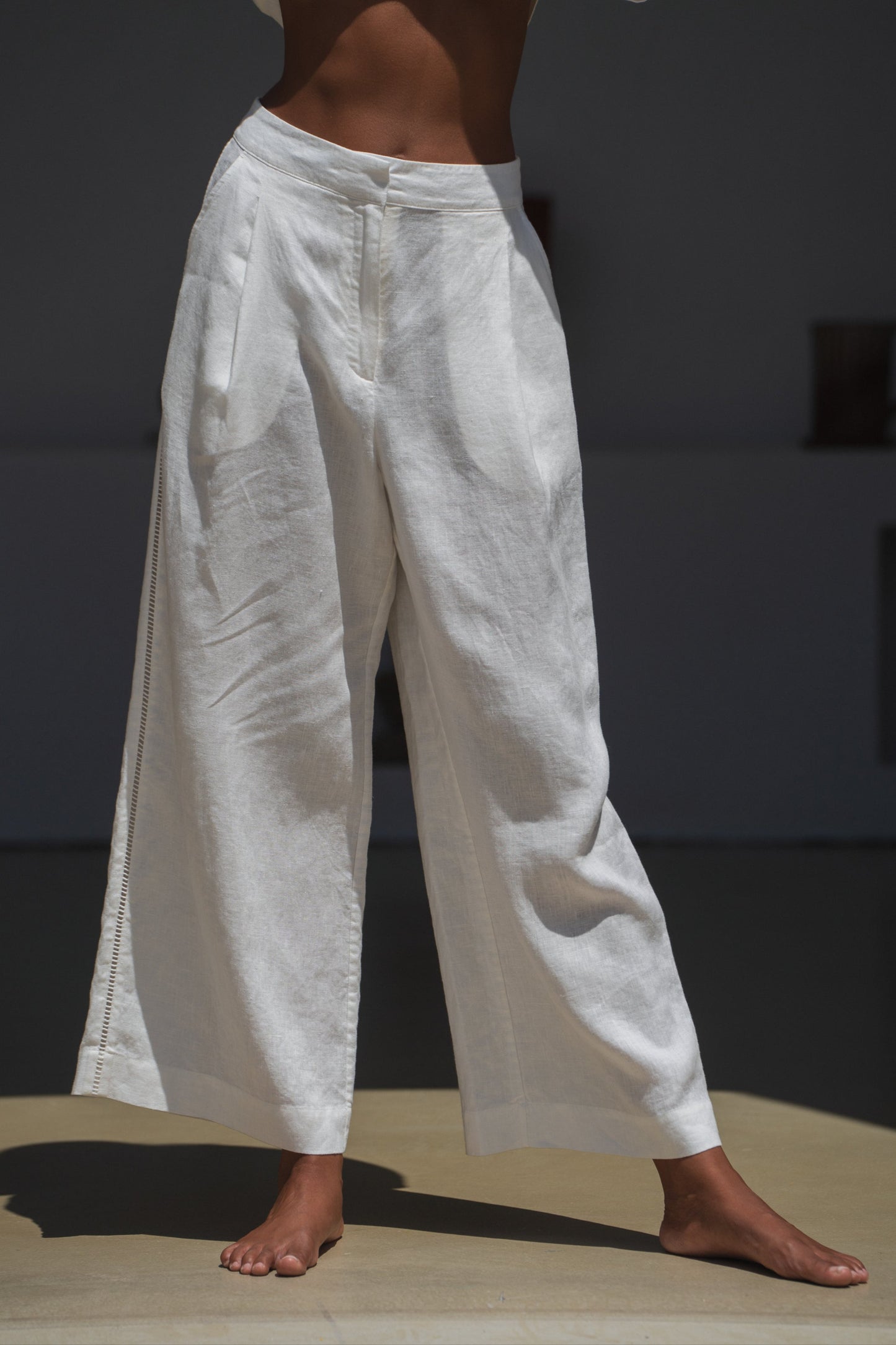 Woman in a ivory Rika linen pants in the sun
