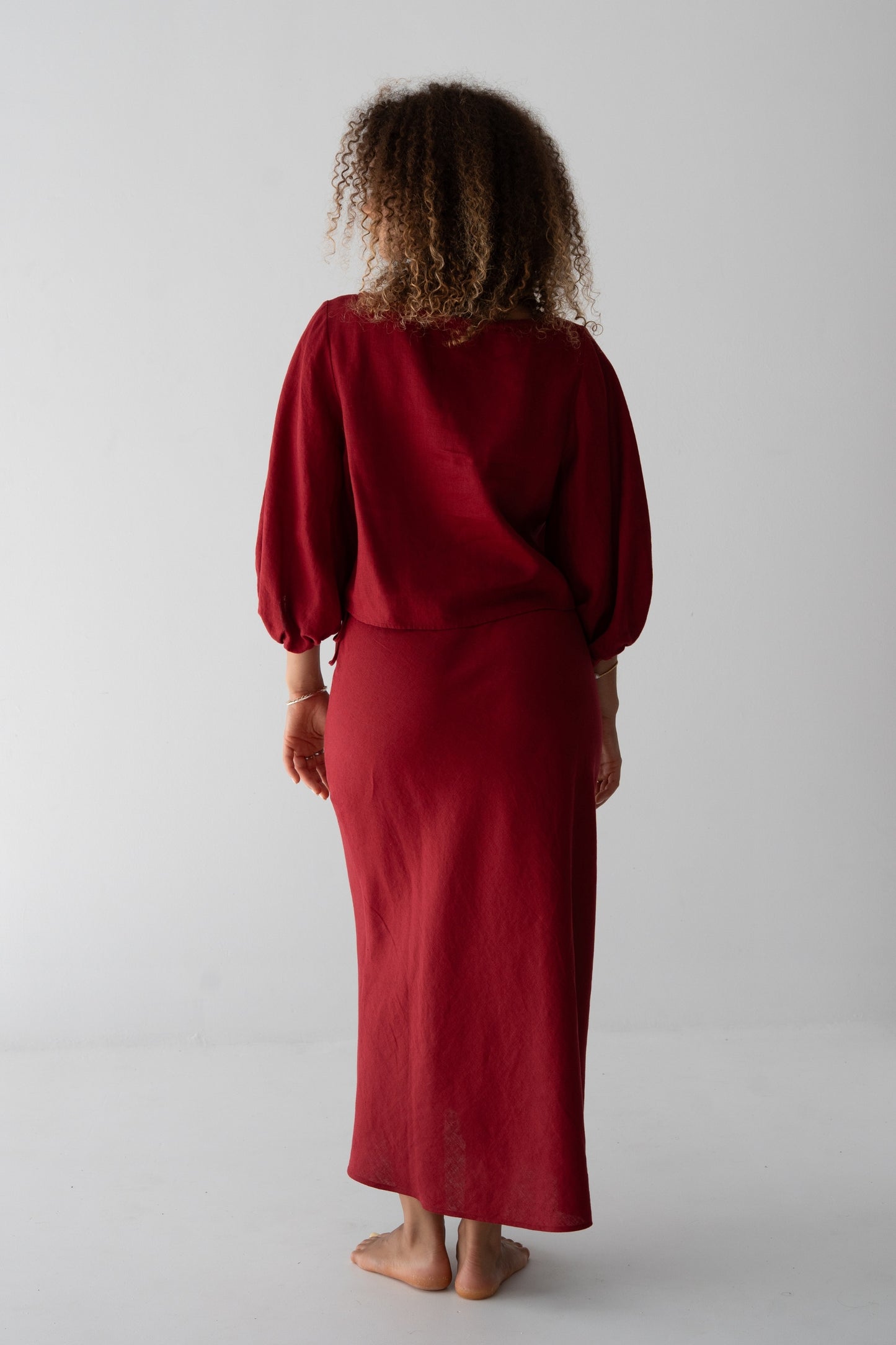 Riley Bias Linen Midi Skirt in Cherry Red - back view, woman wearing Cherry Red linen skirt with matching balloon-sleeve linen crop top - Lilly Pilly Collection